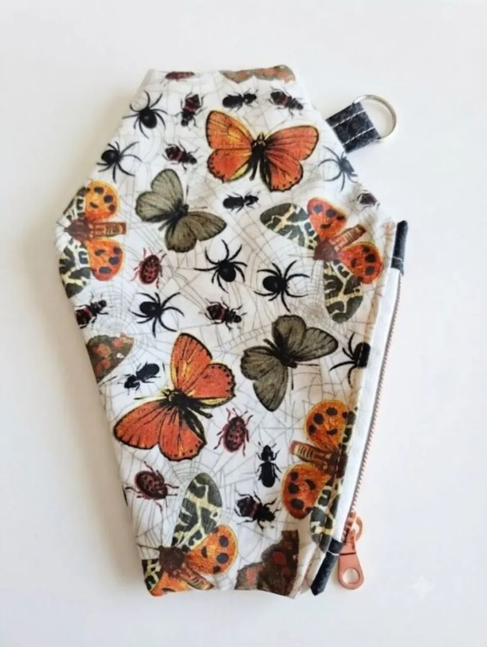 coffin pouch w/ spiders, moths, and Bettles, caught in a web in creme backing